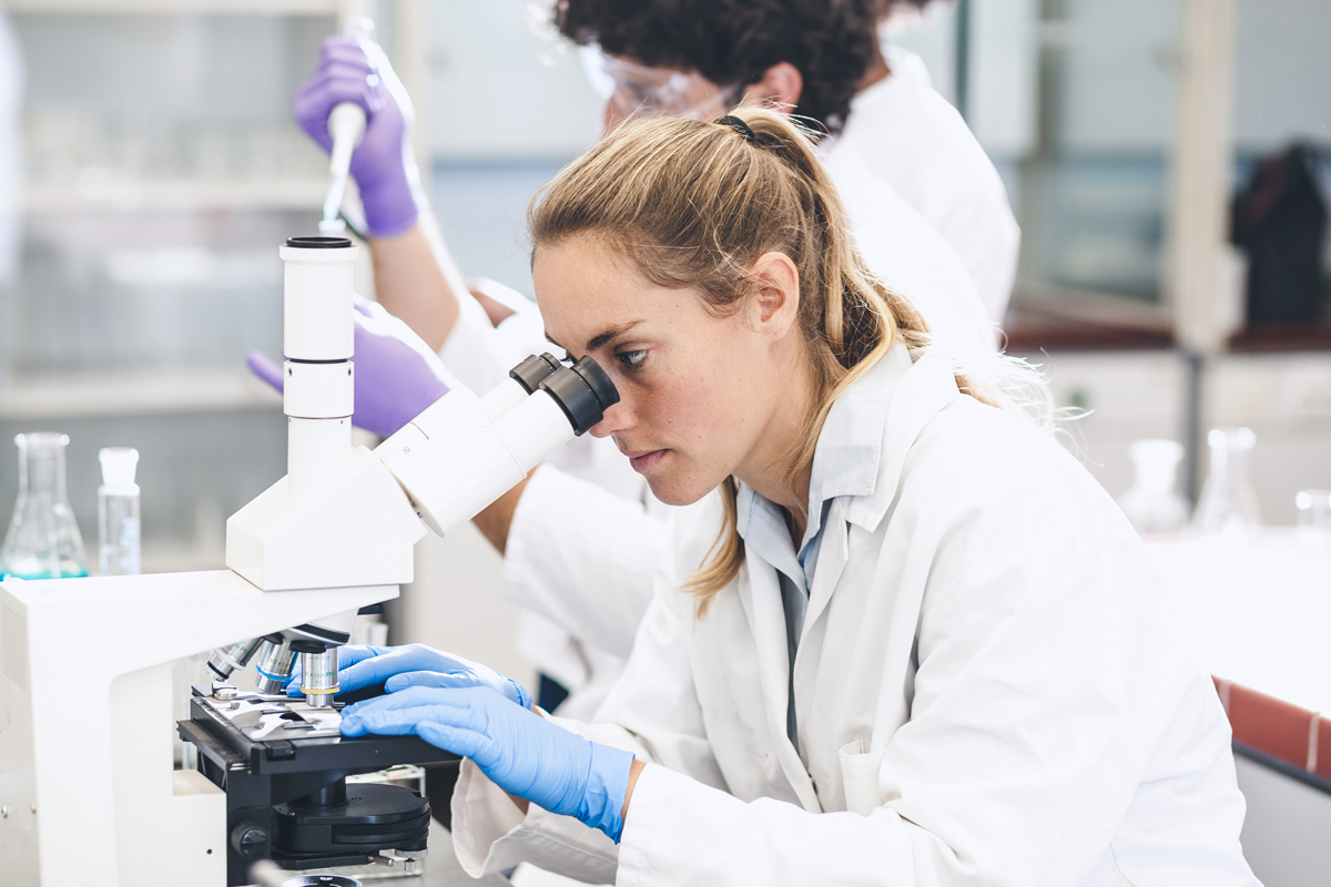 doctor looking through microscope